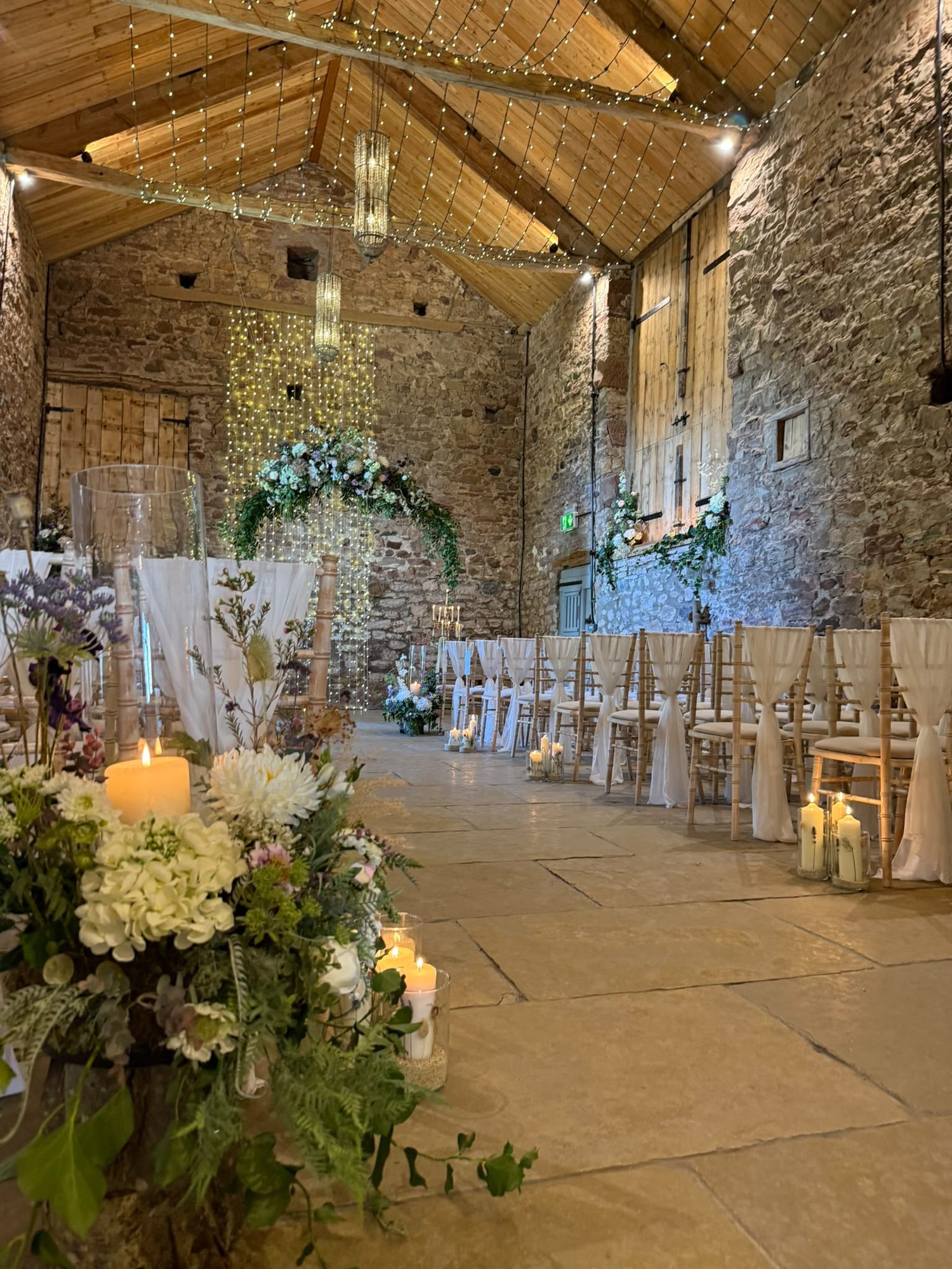 Ceremony room dressed with candles down a flagstone aisle