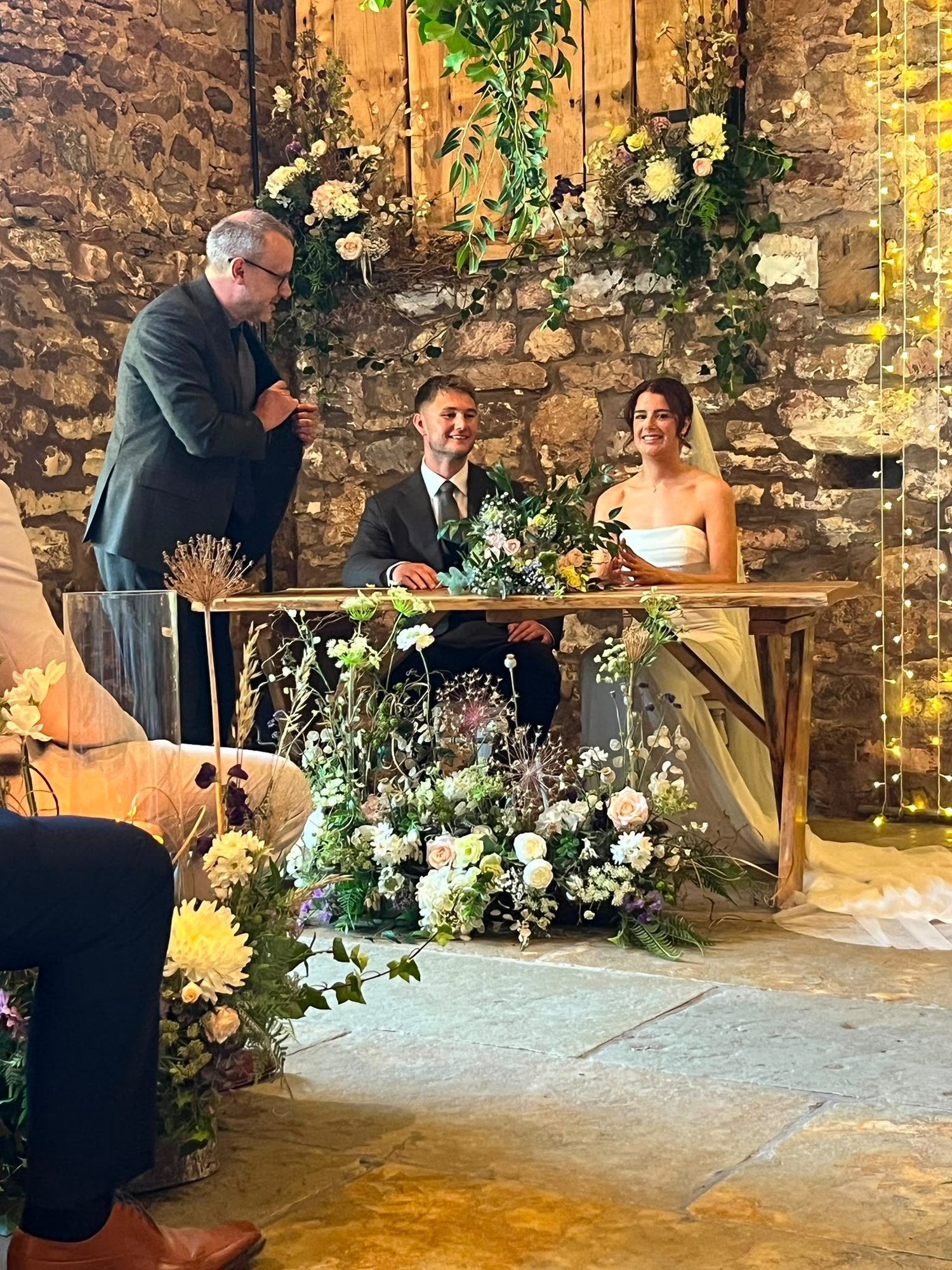 Signing table framed by a low meadow of silk and dried flowers